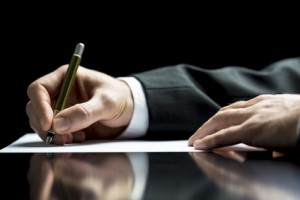 Businessman writing a letter or signing Unternehmensberatung, KMU, Fördermittel